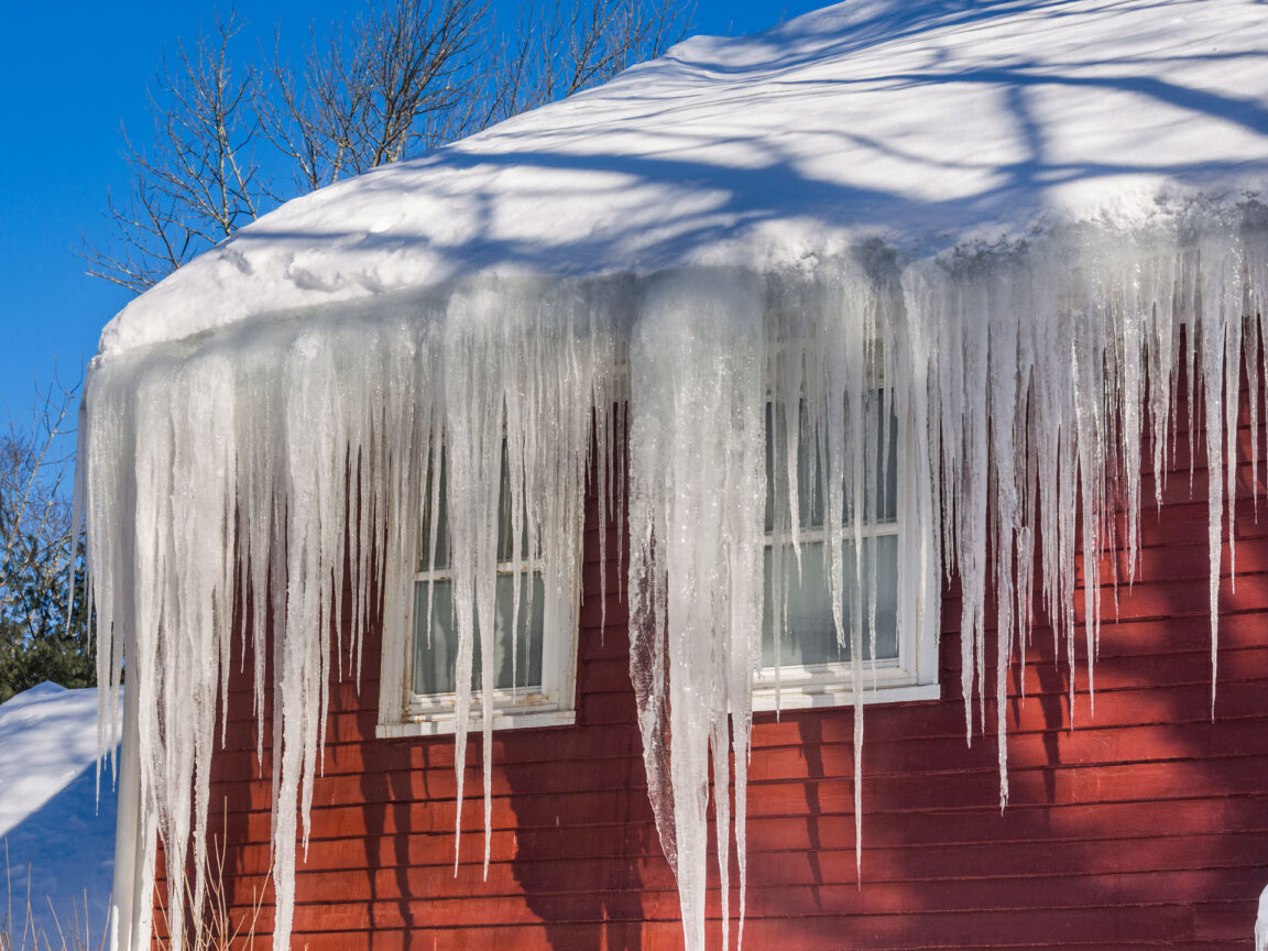 icicles on the eave of a red house