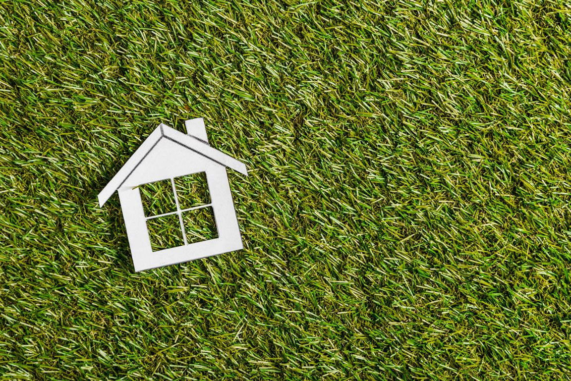 paper house on grass representing energy efficiency