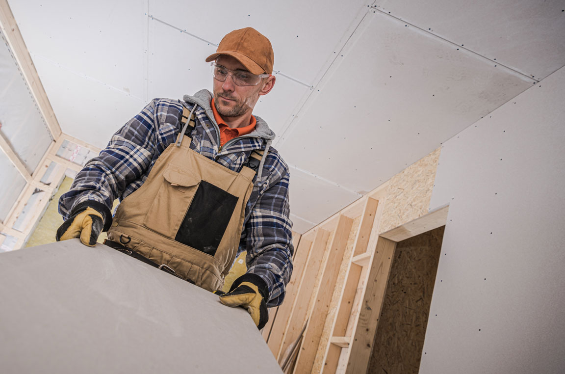 construction worker holding drywall